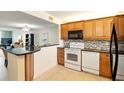 Open concept kitchen with modern appliances, wood cabinets, and breakfast bar at 7625 Sun Island S Dr # 304, South Pasadena, FL 33707