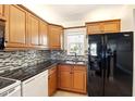 Updated kitchen with granite counters, a mosaic backsplash, and modern black appliances at 7625 Sun Island S Dr # 304, South Pasadena, FL 33707