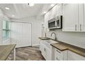 Modern kitchen boasts butcher block countertops, white cabinets, stainless appliances, and farmhouse sink at 816 9Th Sw Ave, Largo, FL 33770