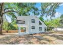 Home exterior with mature trees and featuring a balcony and bright, updated design at 8521 N 29Th St, Tampa, FL 33604