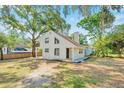 Inviting home exterior features mature trees, a light color scheme, and a covered side porch at 8521 N 29Th St, Tampa, FL 33604