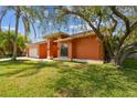 A charming single-story home with vibrant landscaping and a mature tree in the front yard at 8601 Chadwick Dr, Tampa, FL 33635