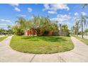 A well-maintained single-story home with palm trees and a mature tree in a landscaped front yard at 8601 Chadwick Dr, Tampa, FL 33635