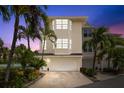 Exterior view of this lovely townhome, showcasing the two-car garage and well-maintained landscaping at 9201 Captiva Cir, St Pete Beach, FL 33706