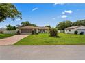 Exterior view of a well-manicured front yard leading to a single story home with attached garage at 1038 Shenandoah Ln, Spring Hill, FL 34606