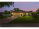 Charming single-story home with a well-maintained lawn and a two-car garage at twilight at 1038 Shenandoah Ln, Spring Hill, FL 34606