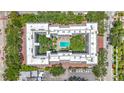 Aerial view of an apartment complex featuring an inner courtyard and swimming pool surrounded by lush trees at 105 4Th Ne Ave # 426, St Petersburg, FL 33701