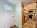 Updated kitchen featuring wood cabinets, stainless steel appliances, wood-look flooring, and a white door at 105 4Th Ne Ave # 426, St Petersburg, FL 33701