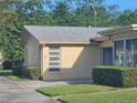 This property features light yellow paint, well-maintained lawns, and neat shrubbery at 1107 Queen Anne Dr # C, Palm Harbor, FL 34684