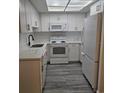 Well-lit kitchen featuring white cabinets, stainless steel appliances, and stylish countertops at 1107 Queen Anne Dr # C, Palm Harbor, FL 34684