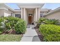 Inviting front entrance with decorative landscaping, a charming pathway, and a solid wood door at 111 Falling Water Dr, Brandon, FL 33511