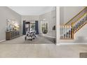 Open-concept living room featuring carpet floors, a staircase with wooden banister, and lots of natural light at 111 Falling Water Dr, Brandon, FL 33511