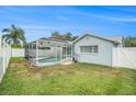 Fenced backyard featuring a screened-in pool enclosure and well-kept lawn at 11222 Clayridge Dr, Tampa, FL 33635