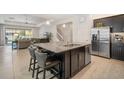 Modern kitchen featuring granite countertops, stainless steel appliances, and a spacious island with seating at 11429 Drifting Leaf Dr, Riverview, FL 33579