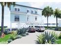 Charming waterfront home on stilts featuring an expansive driveway and a coastal landscape at 131 92Nd Ave, Treasure Island, FL 33706