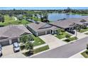 An aerial view of a home with a three-car garage, situated beside a lake, and near other homes in the community at 146 Rain Berry Ave, Ruskin, FL 33570