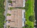 Aerial view of a townhome community featuring red tile roofs, mature landscaping, and access to a waterway at 1622 Lago Vista Blvd, Palm Harbor, FL 34685