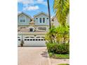 Charming townhome with well-manicured landscaping, a brick paver driveway, and an attached two-car garage at 1622 Lago Vista Blvd, Palm Harbor, FL 34685