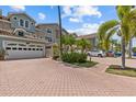 Beautiful multi-story townhome with a brick paver driveway and lush landscaping showcasing its curb appeal at 1622 Lago Vista Blvd, Palm Harbor, FL 34685