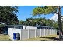 View of the backyard fence and the side of a home, featuring ample privacy and a unique converted bus at 1631 St Mary Dr, Dunedin, FL 34698