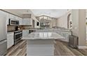 Spacious kitchen features white cabinets, stainless appliances, large windows, and an island with seating at 18017 Palm Breeze Dr, Tampa, FL 33647