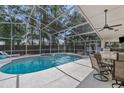 Inviting screened-in pool area featuring a jacuzzi, outdoor kitchen and dining area at 18017 Palm Breeze Dr, Tampa, FL 33647