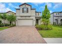 Charming two-story home with manicured landscaping, brick driveway, and a two-car garage at 19238 Old Spanish Rd, Tampa, FL 33647