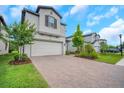 Charming two-story home with manicured landscaping, brick driveway, and a two-car garage at 19238 Old Spanish Rd, Tampa, FL 33647