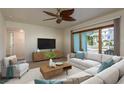 Bright living room featuring a large window, ceiling fan, and comfortable seating arrangement with modern decor at 2010 Bayview Pl, Indian Rocks Beach, FL 33785