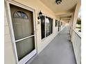 Exterior hallway leading to Unit 38 featuring neutral paint, railing, and a street lamp above the unit number at 2434 Australia E Way # 38, Clearwater, FL 33763