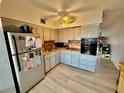 Bright kitchen featuring ample cabinet space, light wood flooring, and stainless steel refrigerator at 2434 Australia E Way # 38, Clearwater, FL 33763