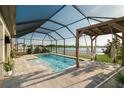 Relaxing screened-in pool area with a hammock, spa, and views of the lake, offering the perfect outdoor retreat at 3091 King Fern Dr, Wimauma, FL 33598