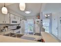 Bright kitchen features white appliances, ample cabinet space, and a breakfast bar at 311 Knottwood Ct, Sun City Center, FL 33573