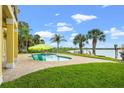 Enjoy the serene backyard with a refreshing pool, lush landscaping, and picturesque water views, perfect for relaxation at 3236 Gulf Winds Cir, Hernando Beach, FL 34607