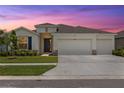 Charming single-story home featuring a three-car garage, well-manicured lawn, and appealing architectural details at 33700 Hamilton Hill Ln, Wesley Chapel, FL 33545