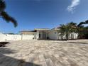 Charming one-story house with a red tile roof, a paved driveway, palm trees, and a two-car garage at 3691 Center Cir, Largo, FL 33774