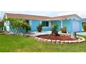Landscaped front yard featuring lush green lawn and stone-bordered flower beds accentuating this quaint home at 3839 Star Island Dr, Holiday, FL 34691