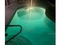 Inviting pool illuminated by vivid turquoise underwater lights and convenient step access at 4500 Onorio St, New Port Richey, FL 34653