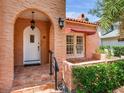 Charming stucco home featuring an arched entryway, red-tiled roof, and white-trimmed door at 4521 W Azeele St, Tampa, FL 33609