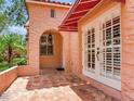 Close up view of a peach stucco home featuring a red tiled roof, arched doorway, and white trimmed doors at 4521 W Azeele St, Tampa, FL 33609