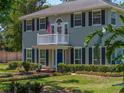 A lovely two-story home with a balcony, well-manicured lawn, a landscaped garden, and dark window shutters at 4611 Ackerly Way, Brandon, FL 33511