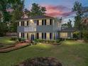 An inviting home featuring a lush lawn, landscaped garden, brick walkway, covered entry, and a balcony at 4611 Ackerly Way, Brandon, FL 33511