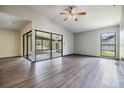 Open living space with wood-look floors, ceiling fan and access to sunroom at 5115 Stonehaven Ct, Tampa, FL 33624