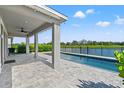 Outdoor living space with covered patio overlooking the pool and scenic lake views under a clear sky at 6123 Golden Nettle Dr, Apollo Beach, FL 33572