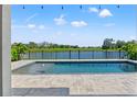 Beautiful in-ground pool featuring lake views, complemented by an extended patio for ultimate relaxation at 6123 Golden Nettle Dr, Apollo Beach, FL 33572