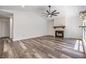 Bright living room with a vaulted ceiling, a modern ceiling fan, and a cozy fireplace with wood-look floors at 660 Channing Dr, Palm Harbor, FL 34684