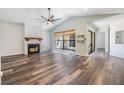 Spacious living room with a fireplace, high ceilings, wood-look flooring, and natural light streaming through a large window at 660 Channing Dr, Palm Harbor, FL 34684