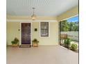 Charming covered front porch, featuring a dark wood door and decorative plants at 909 E 15Th Ave, Tampa, FL 33605