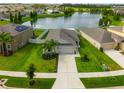 Aerial shot of a home showcasing its well-kept lawn, the nearby pond and proximity to other homes in the neighborhood at 10512 Fuzzy Cattail St, Riverview, FL 33578
