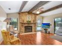 Cozy living room with a brick fireplace, wood beams, and natural light at 107 Halton Cir, Seffner, FL 33584